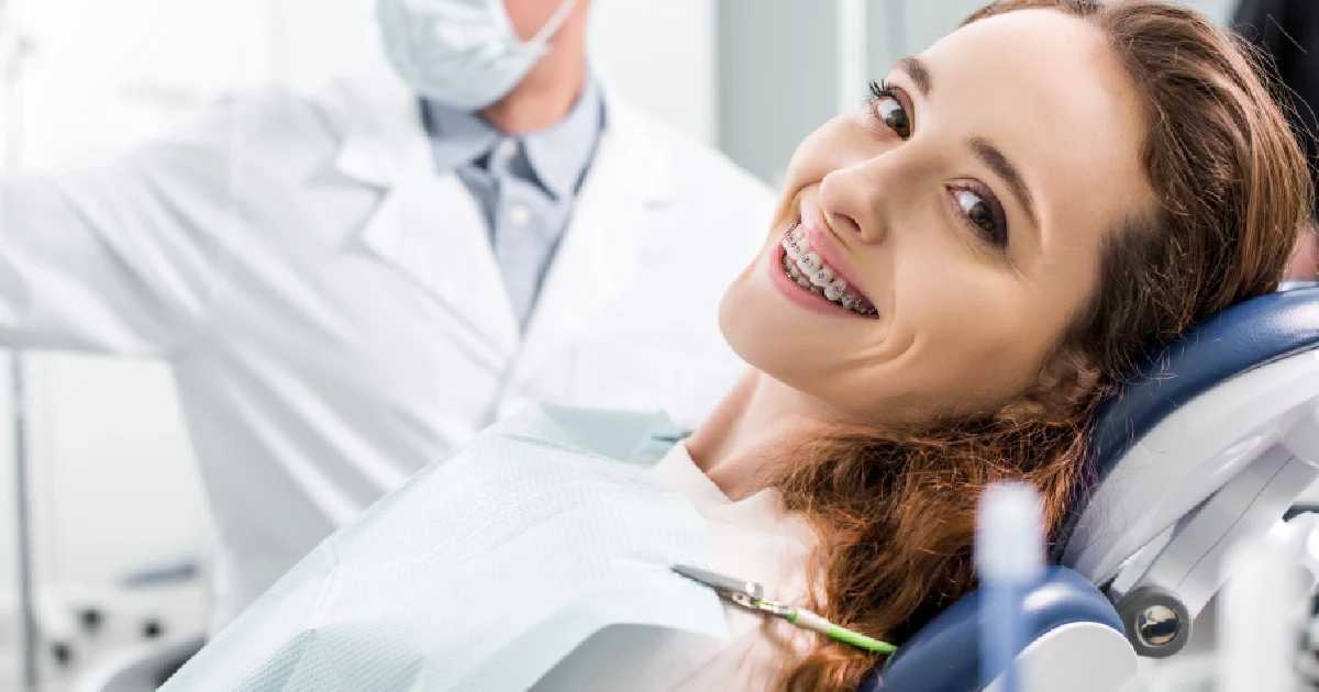 A woman with braces smiles during an orthodontic check-up in Chandler, AZ